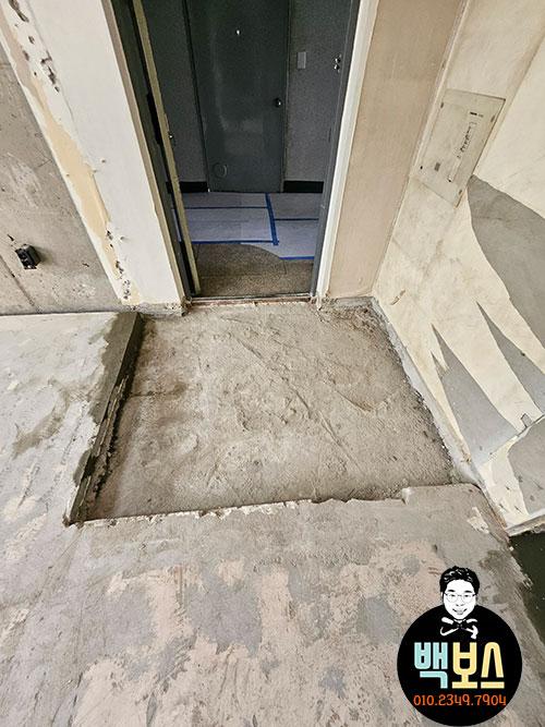 콘크리트 바닥과 벽면이 노출된 현관 철거 과정