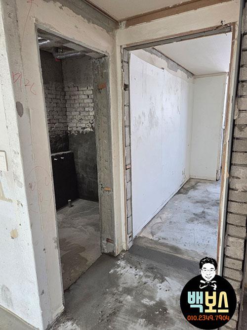 미장 벽면과 노출 브릭 벽이 보이는 내부 복도