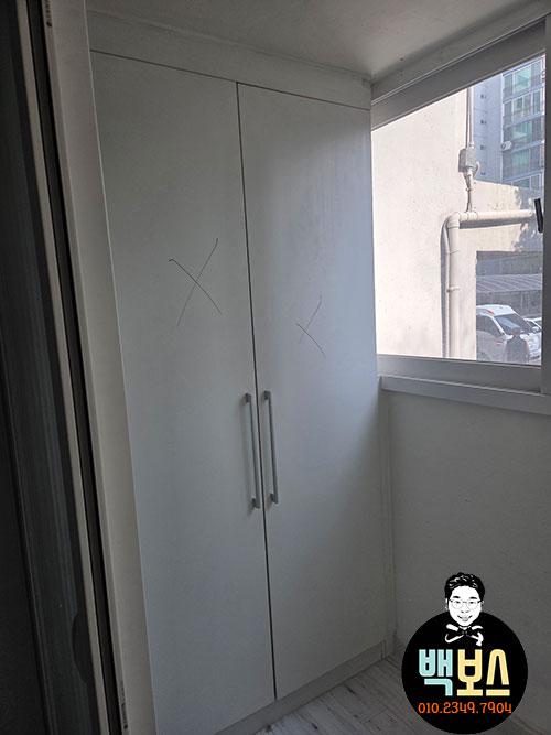 흰색 벽과 창호가 있는 공간의 두문 수납장
