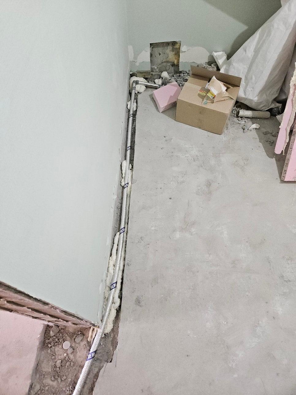 새 배관 연결 후 깔끔하게 미장된 바닥