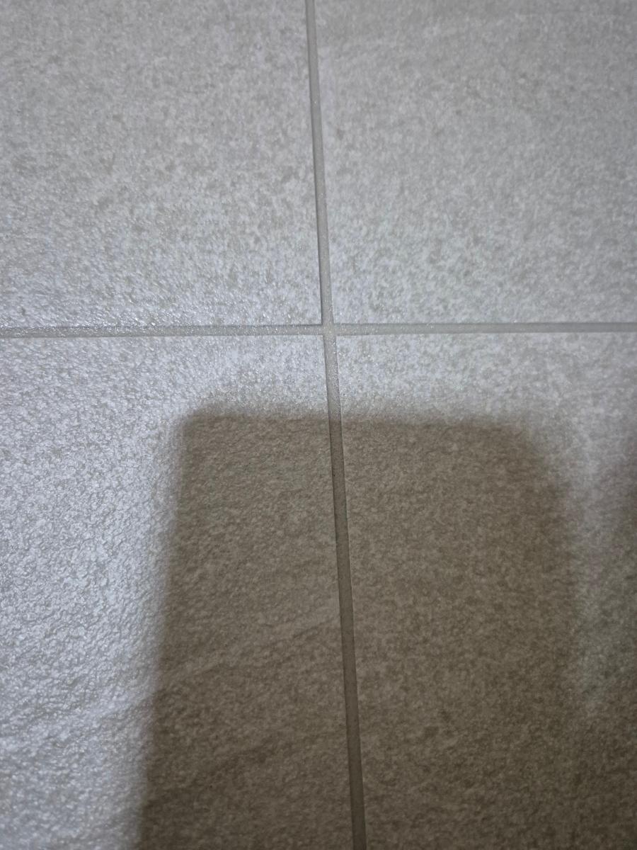 회색 타일 바닥과 흰색 벽지가 맞닿은 부분