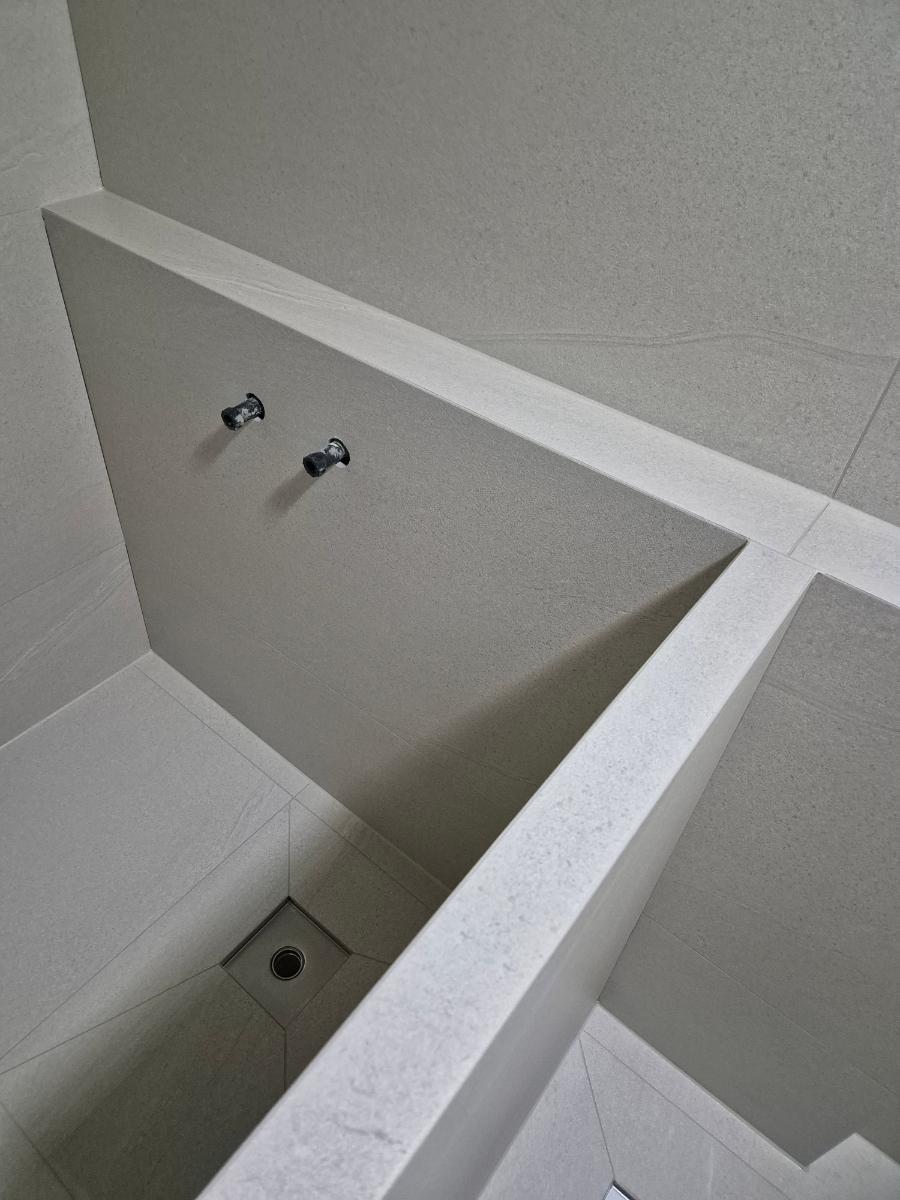 수도꼭지와 배수구가 설치된 흰색 타일 내부