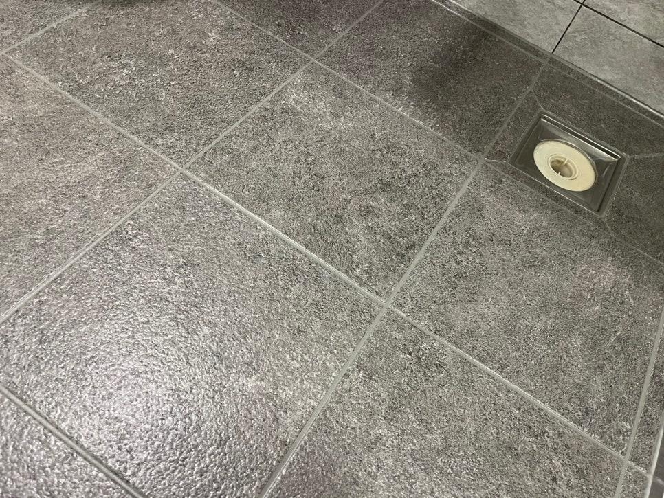 내장형 배수구가 설치된 회색 타일 바닥
