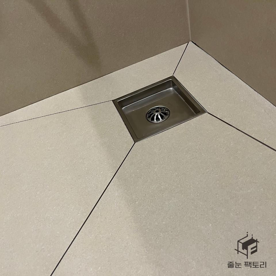 바닥 타일과 스테인리스 배수구의 디테일