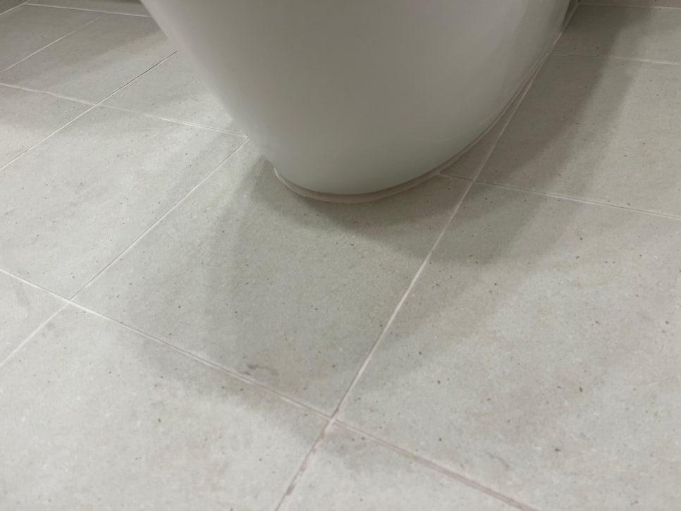 흰색 타일 바닥과 세면대 하단 접합부