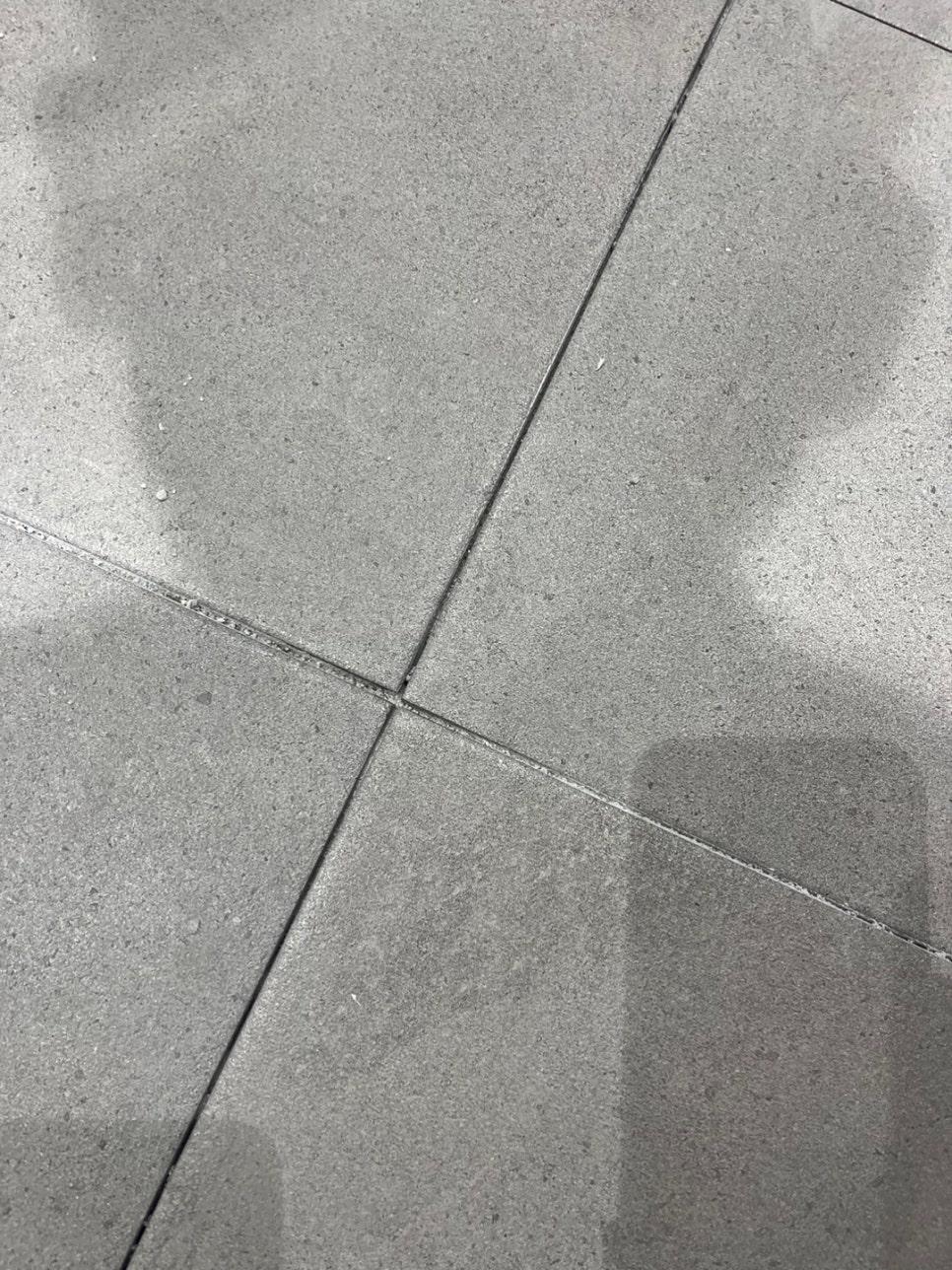 회색 타일 바닥 틈새의 클로즈업