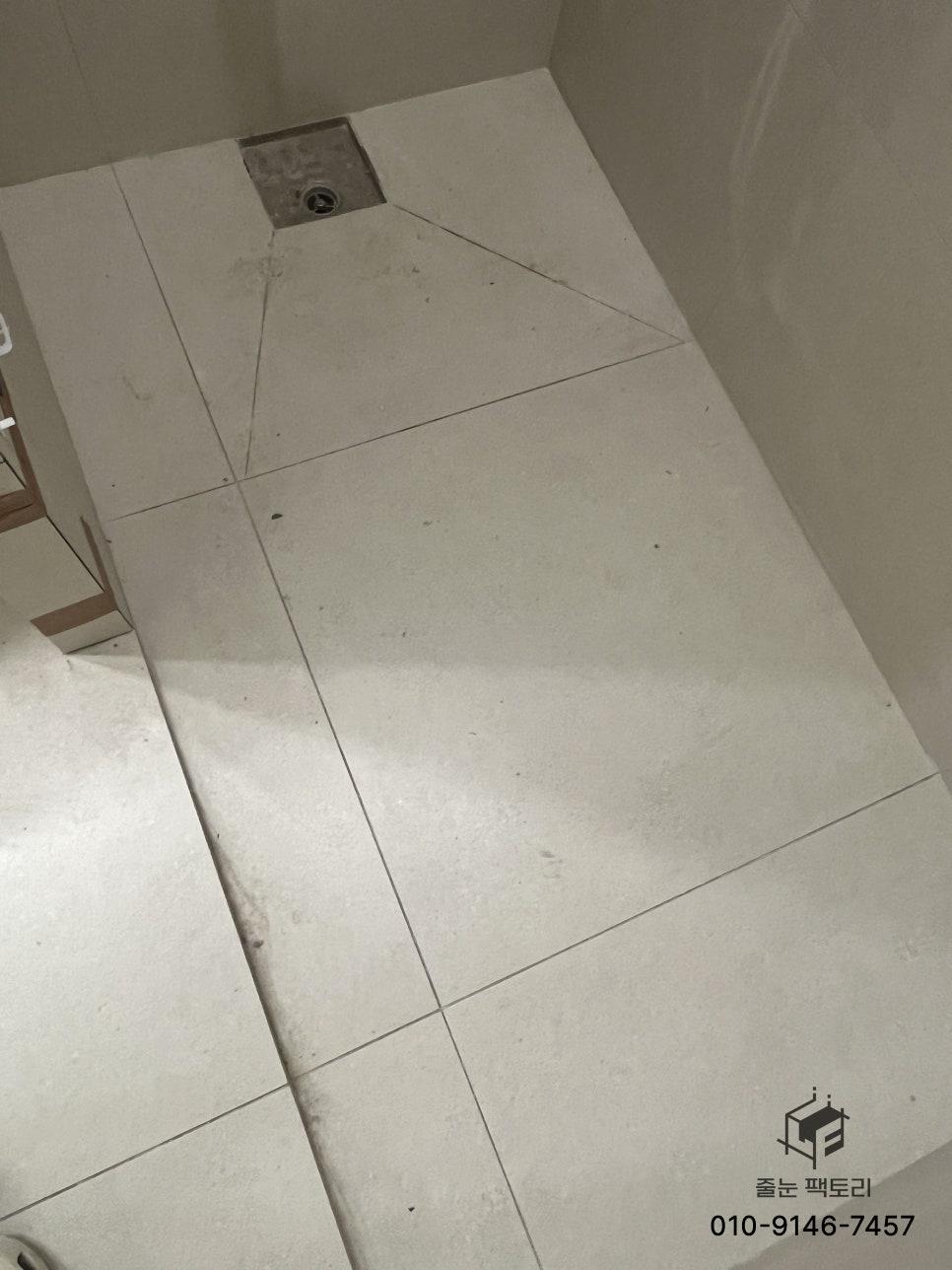 배수구가 있는 흰색 타일 바닥