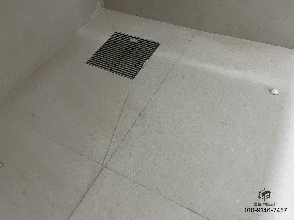 회색 타일과 블랙 드레인이 깔끔하게 마감된 바닥