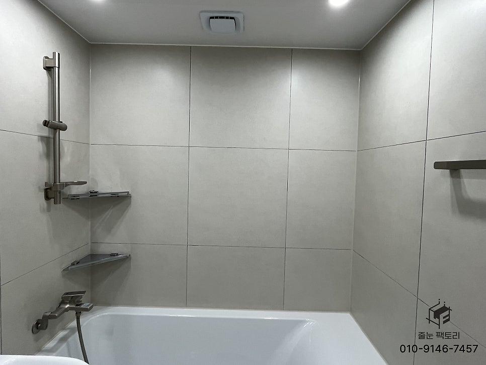 흰색 타일 벽과 스테인리스 샤워 선반이 있는 공간