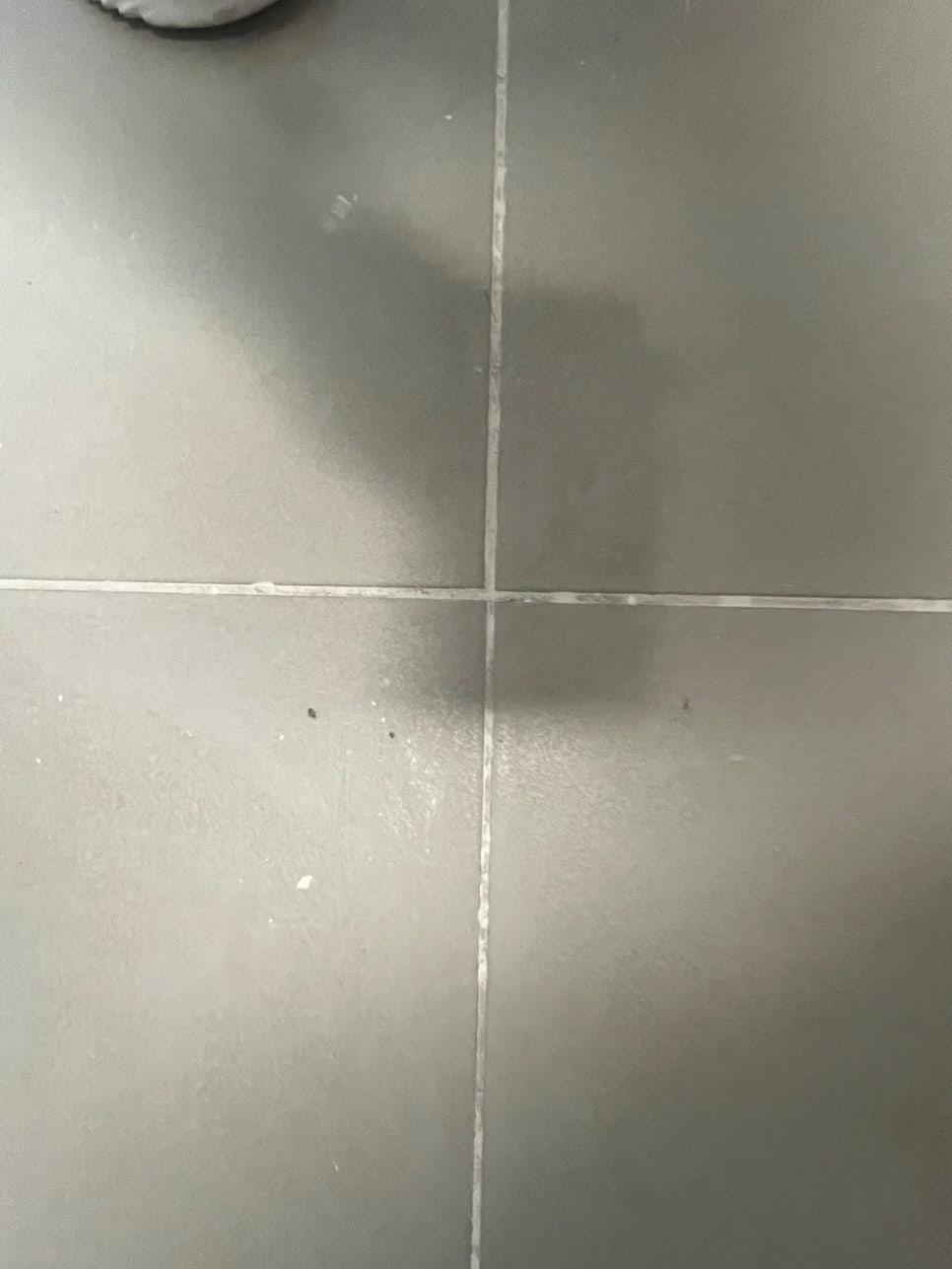 오염과 얼룩이 보이는 회색 타일 바닥 틈새