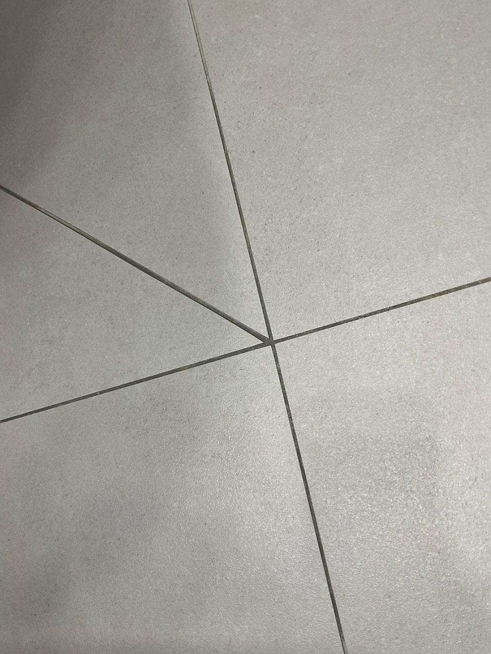 회색 타일 바닥의 교차하는 틈새 클로즈업