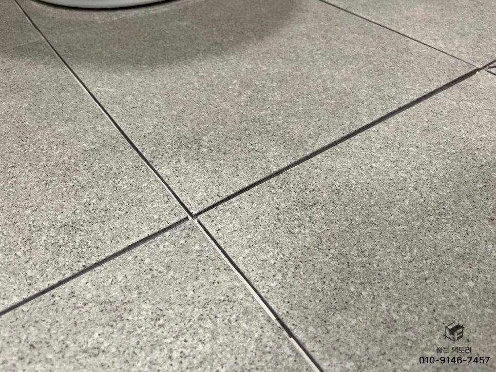 회색 타일 바닥과 흰색 실리콘 접합부
