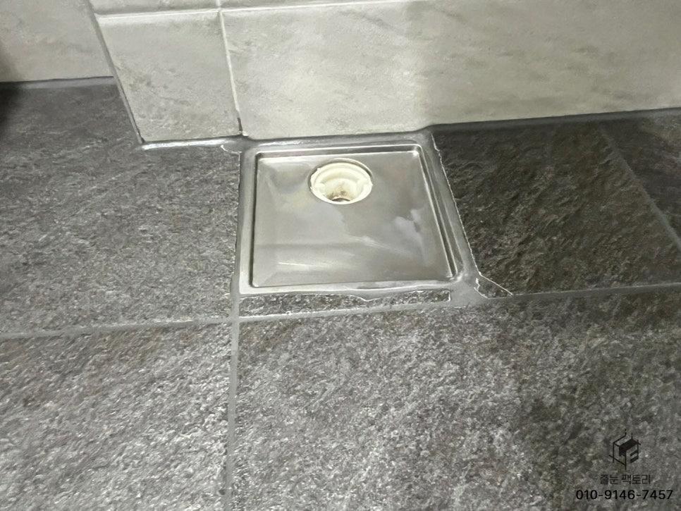 회색 타일 바닥 위 스테인리스 싱크볼