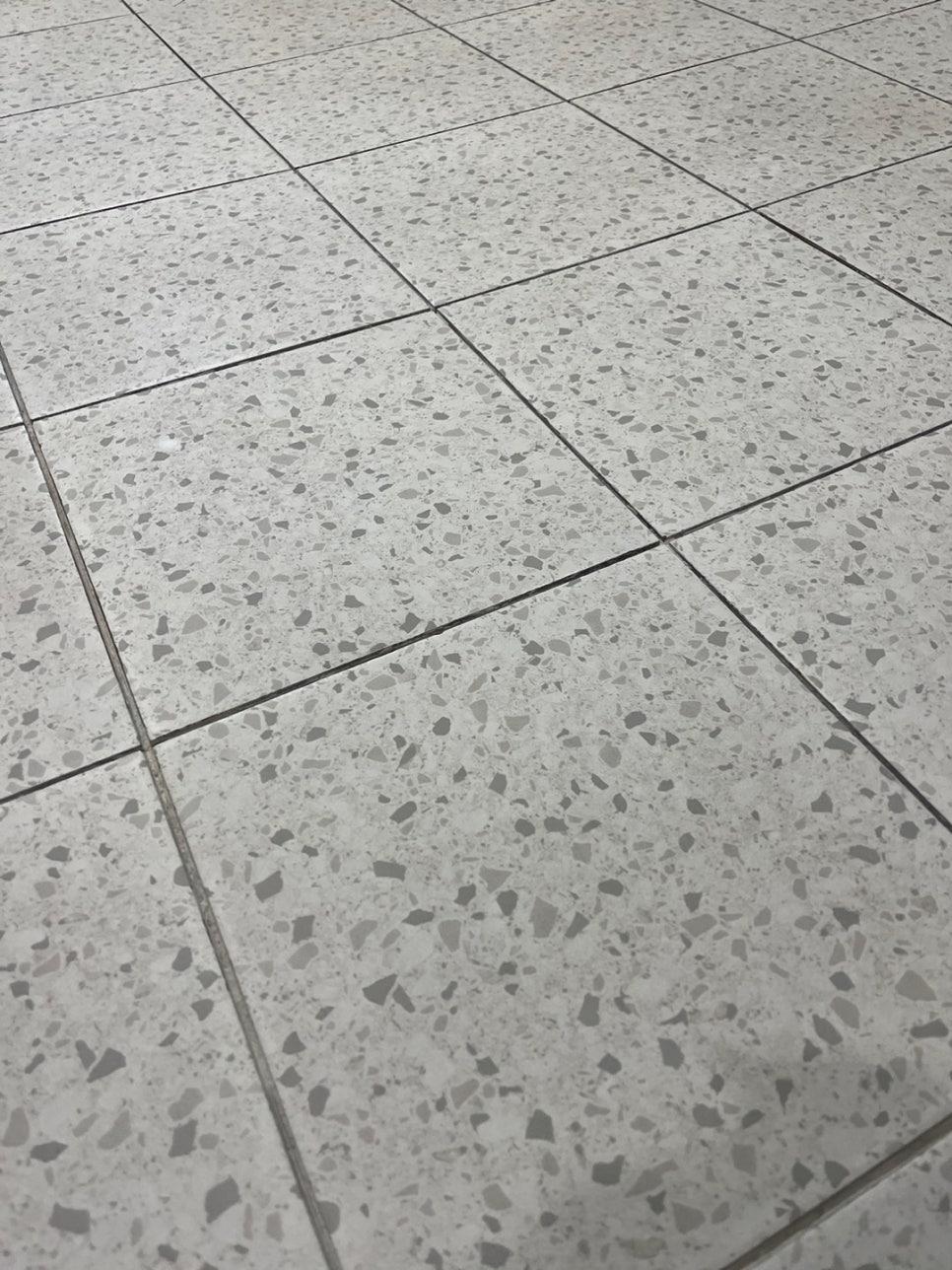 흰색 바탕에 회색 조각이 섞인 타일 바닥