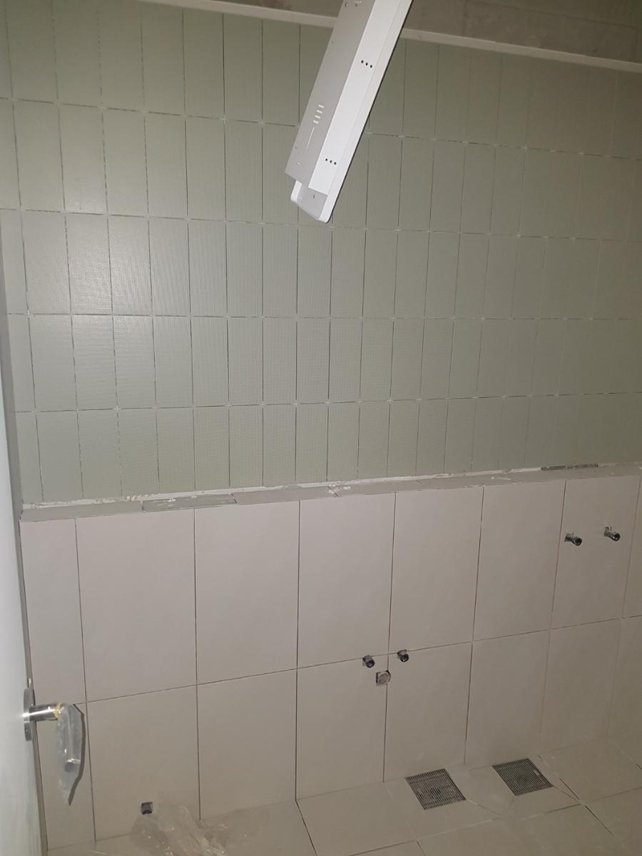 벽 타일 사이를 채워가는 줄눈 시공 과정
