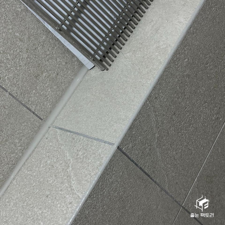 타일 바닥과 금속 라디에이터의 접합부