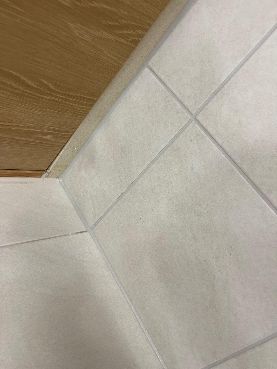 바닥 타일과 상부 목재 마감 사이의 틈새