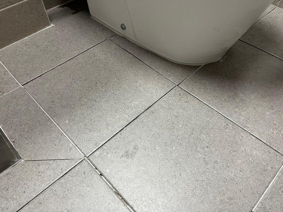 회색 타일 바닥과 욕조 하단 틈새 근접샷