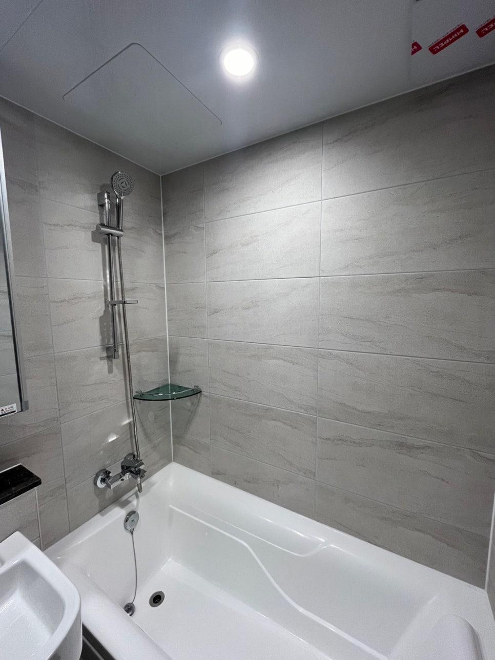 욕조와 세면대, 샤워 설비가 보이는 욕실 벽 타일