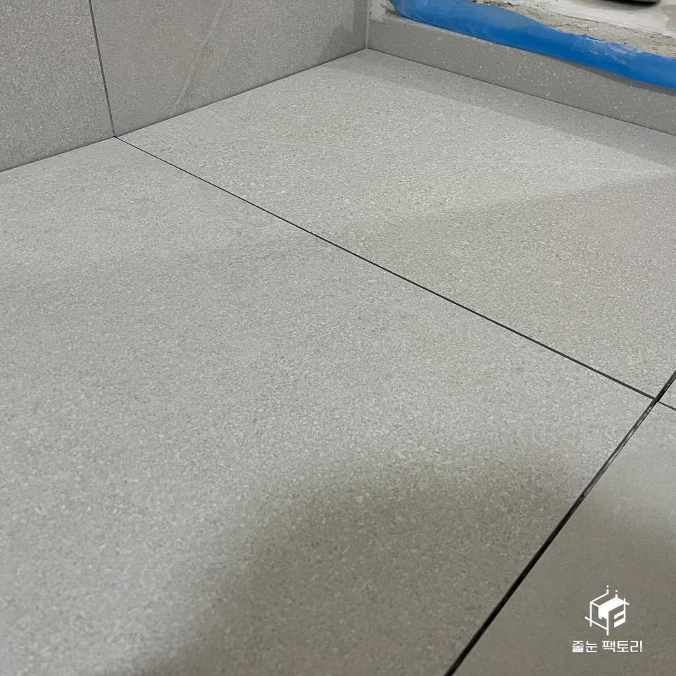 회색 타일 사이의 흑색 실리콘 틈