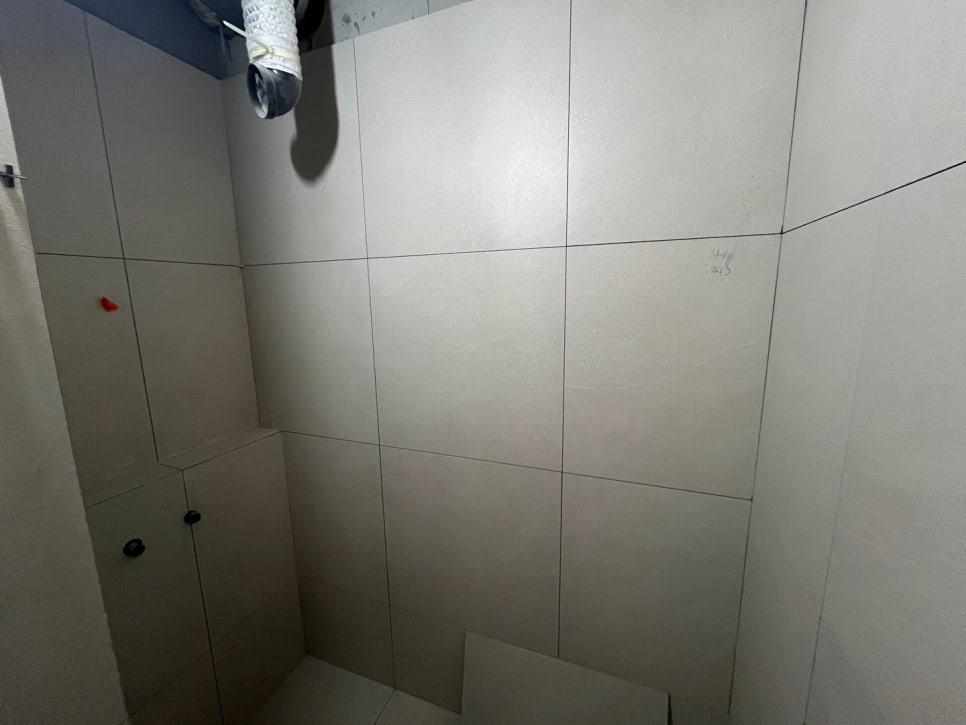 파이프가 설치된 흰색 타일 벽면과 천장