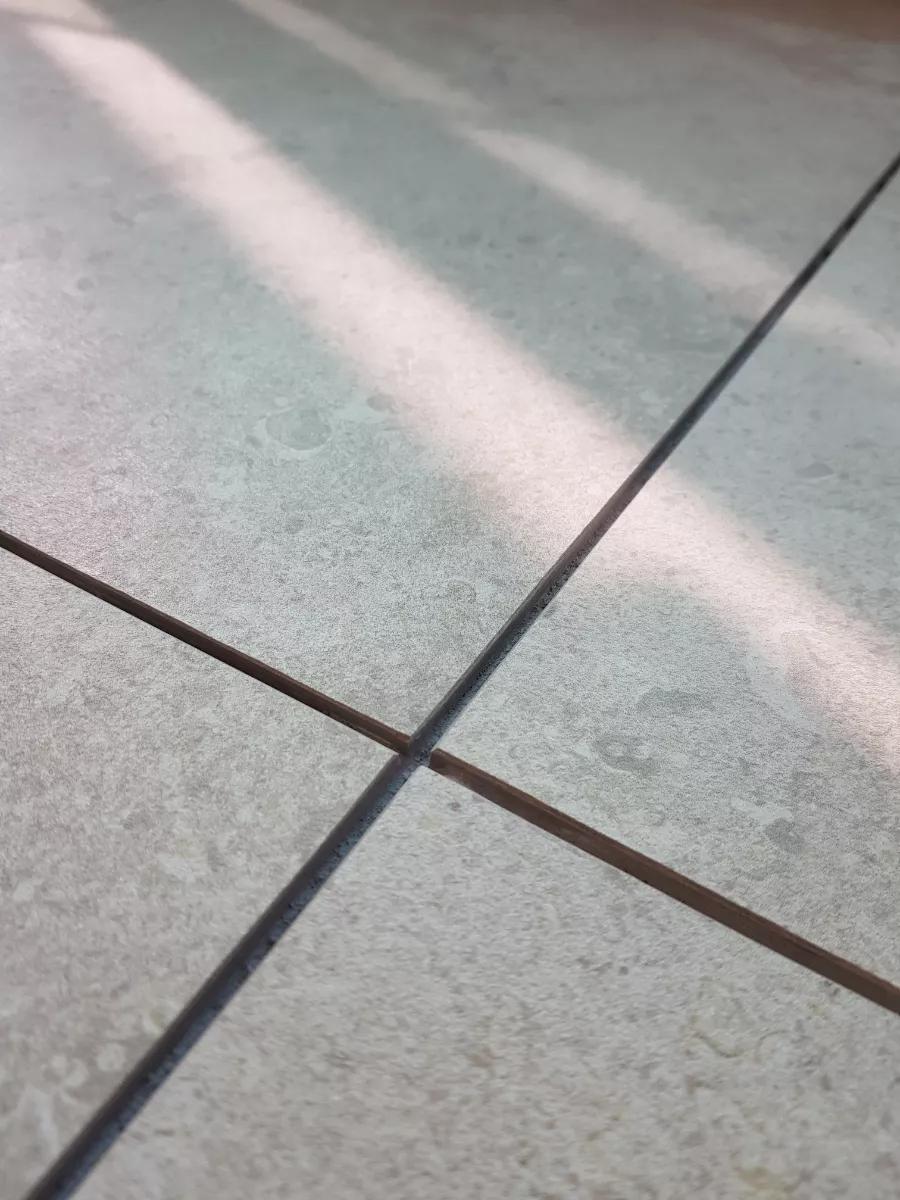 검은색 줄눈이 적용된 회색 타일 바닥