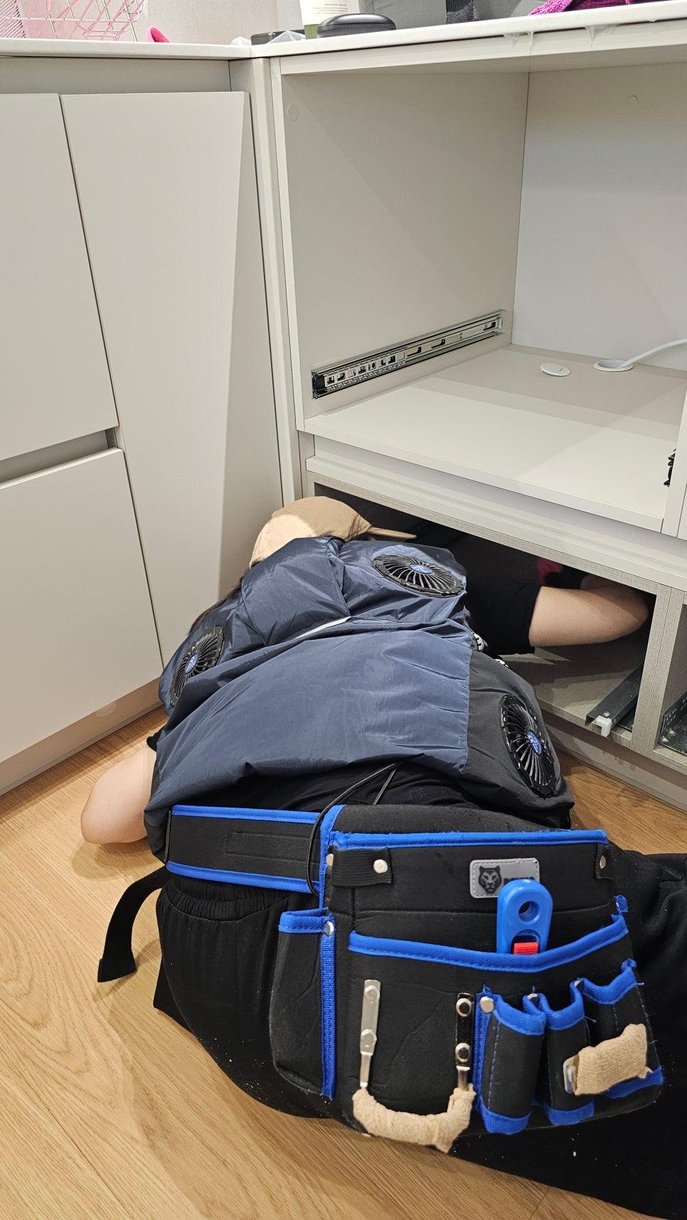 목재 마루와 흰색 수납장이 있는 서재 내부