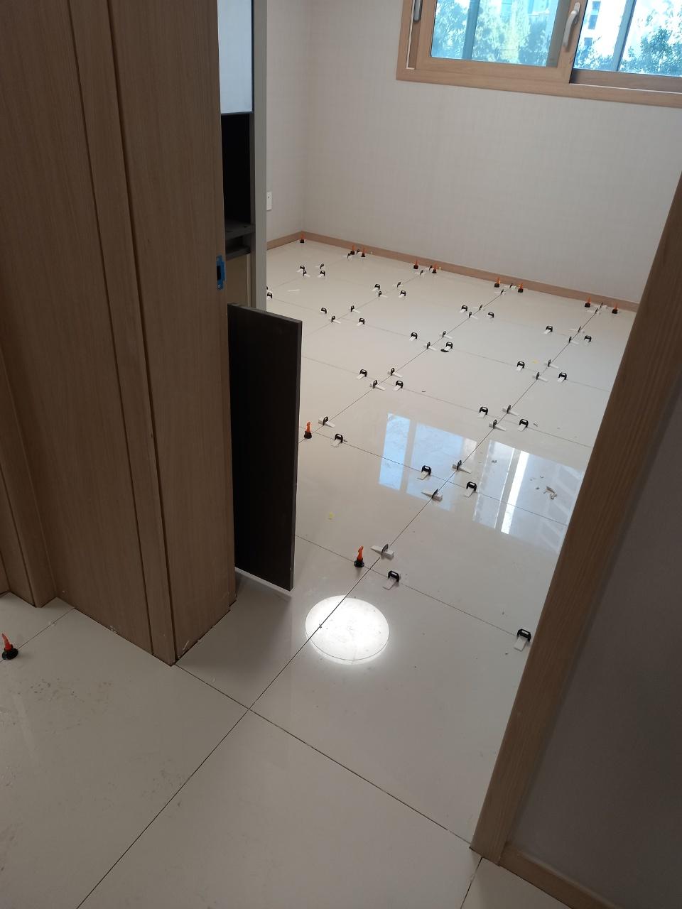 수평을 잡기 위해 보조 장치를 배치한 타일 바닥