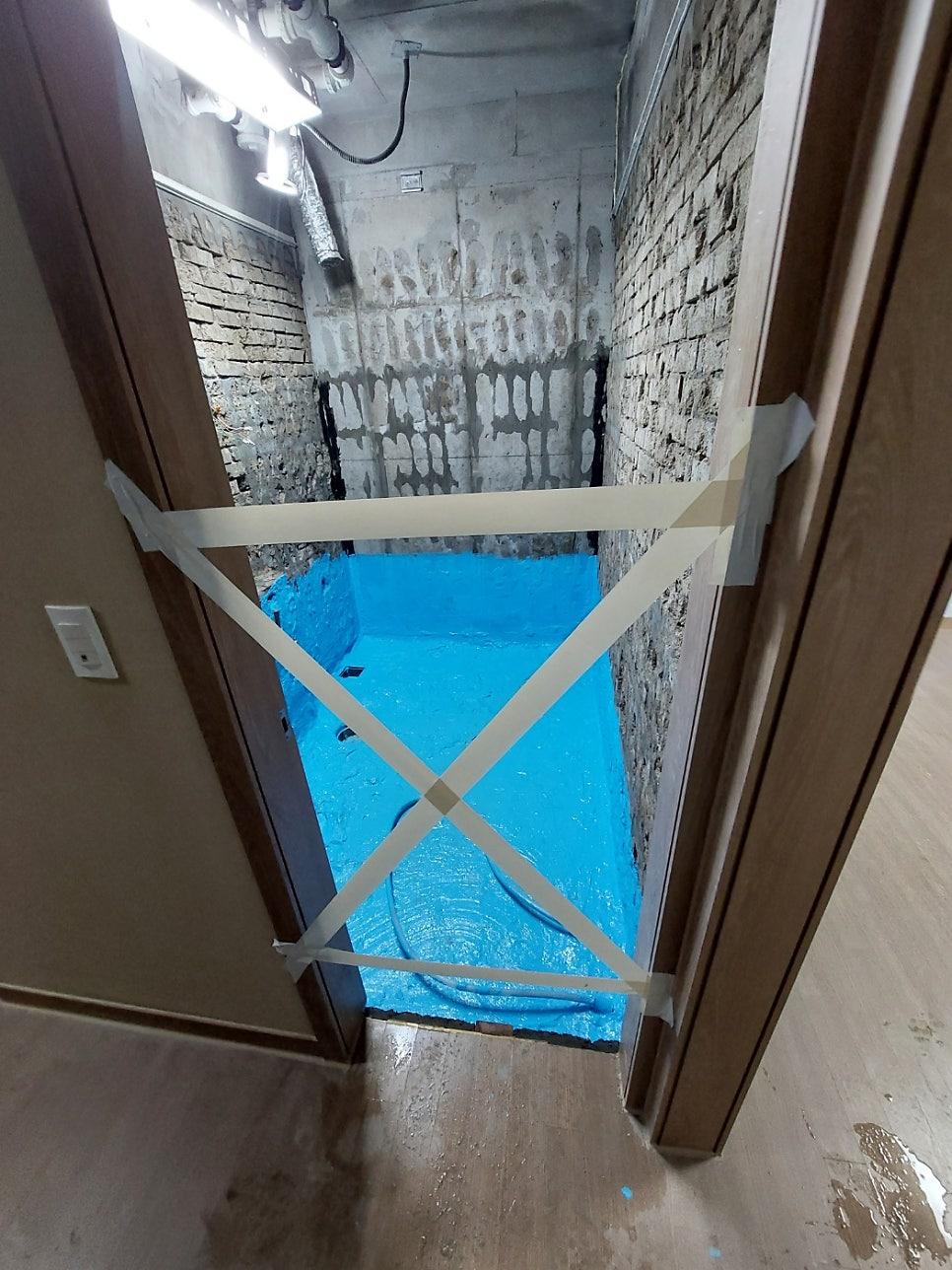 테이프로 막힌 문과 파란색 마감재가 덮인 내부 작업 공간