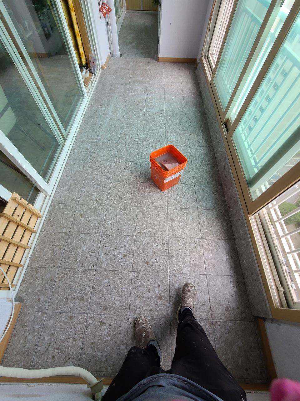 바닥 타일 철거 과정과 오렌지색 물통
