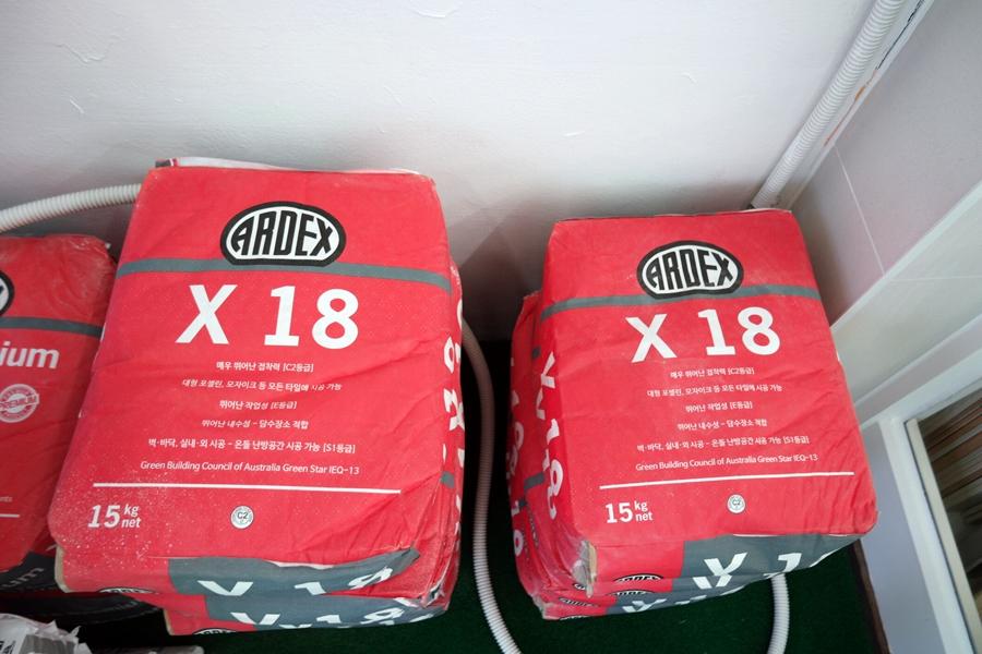 벽 근처에 배치된 ARDEX X 18 자재 패키지