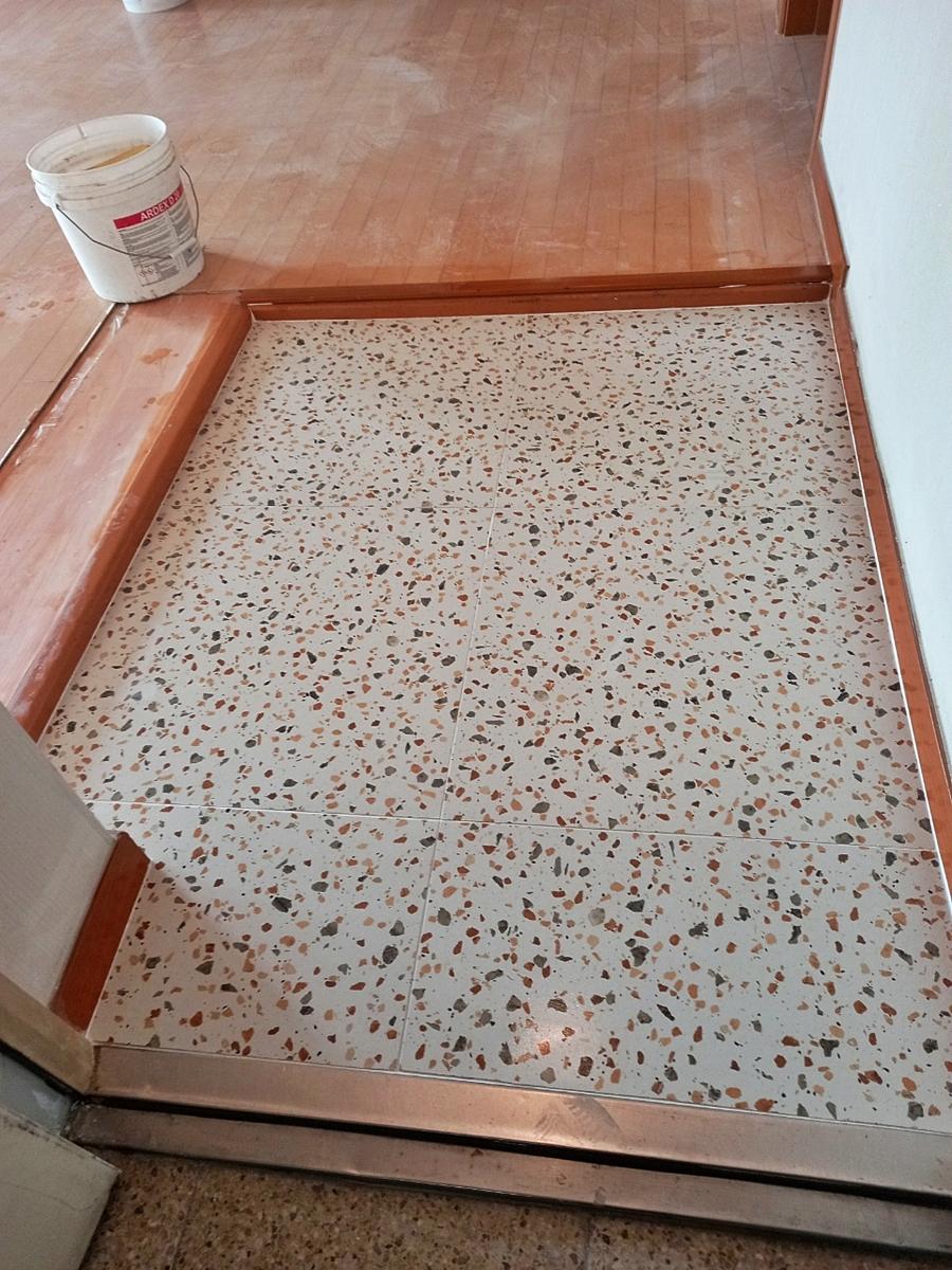 바닥 타일 시공 중인 현장과 흰색 자재 통