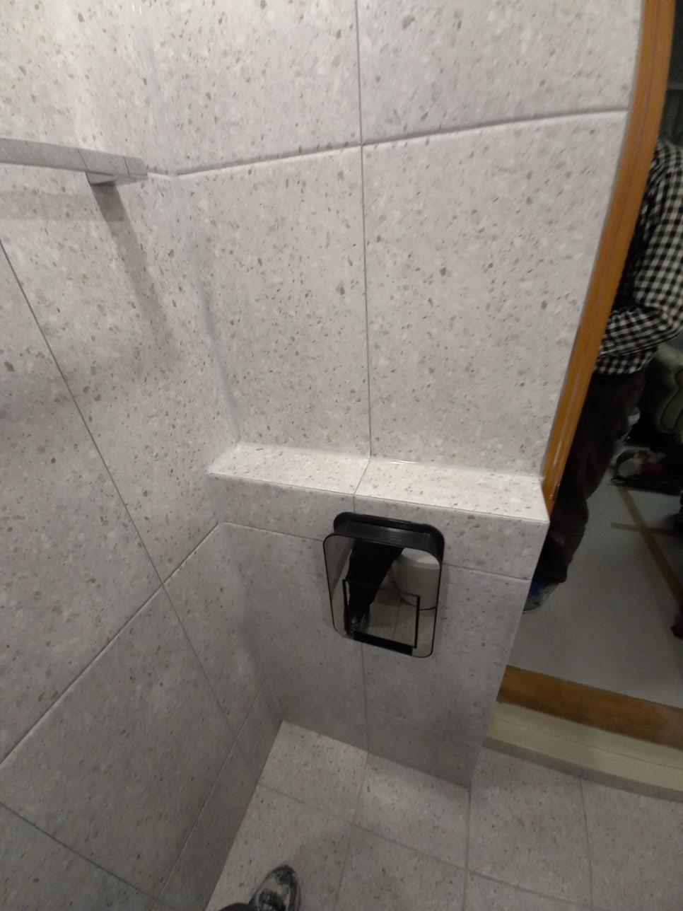 흰색 점박이 타일 벽면에 부착된 검은색 프레임 수납장