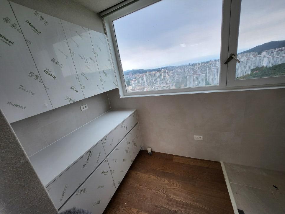 흰색 수납장과 창호가 있는 보조 주방 작업 현장