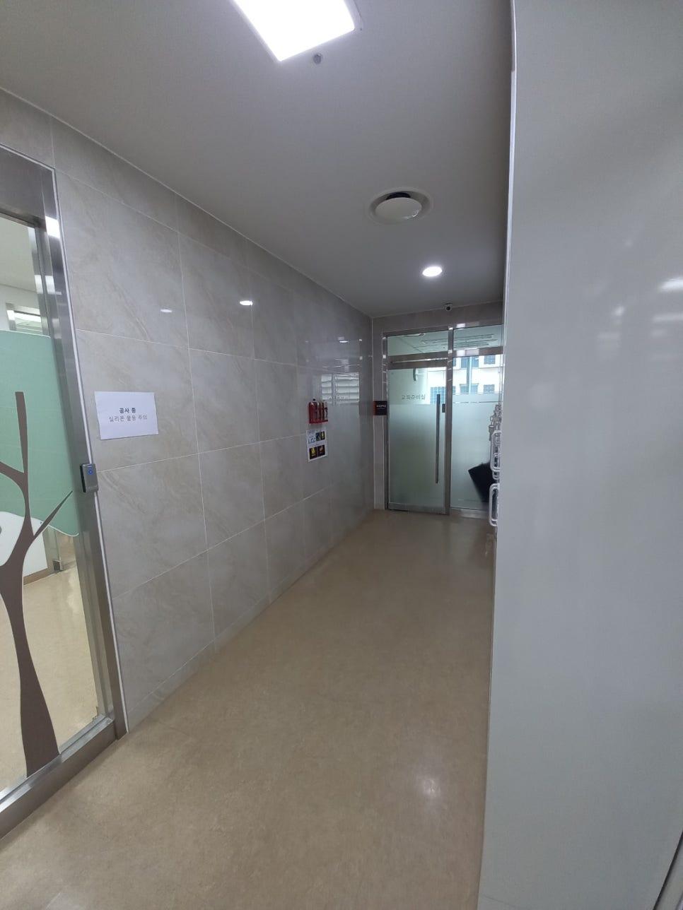 베이지색 타일 마감 중인 벽면과 천장 환기구
