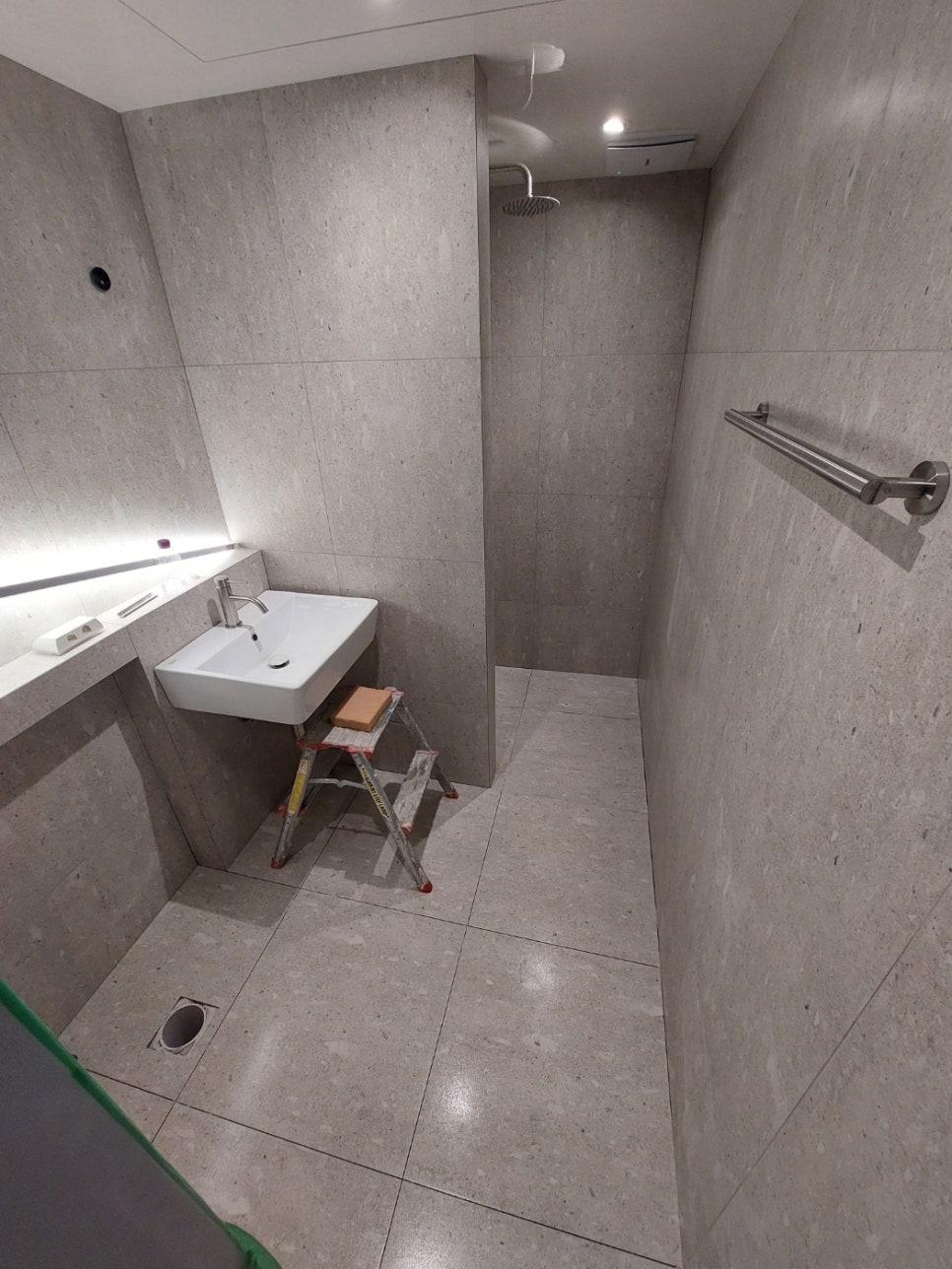 세면대와 샤워 설비 주변의 타일 작업 과정