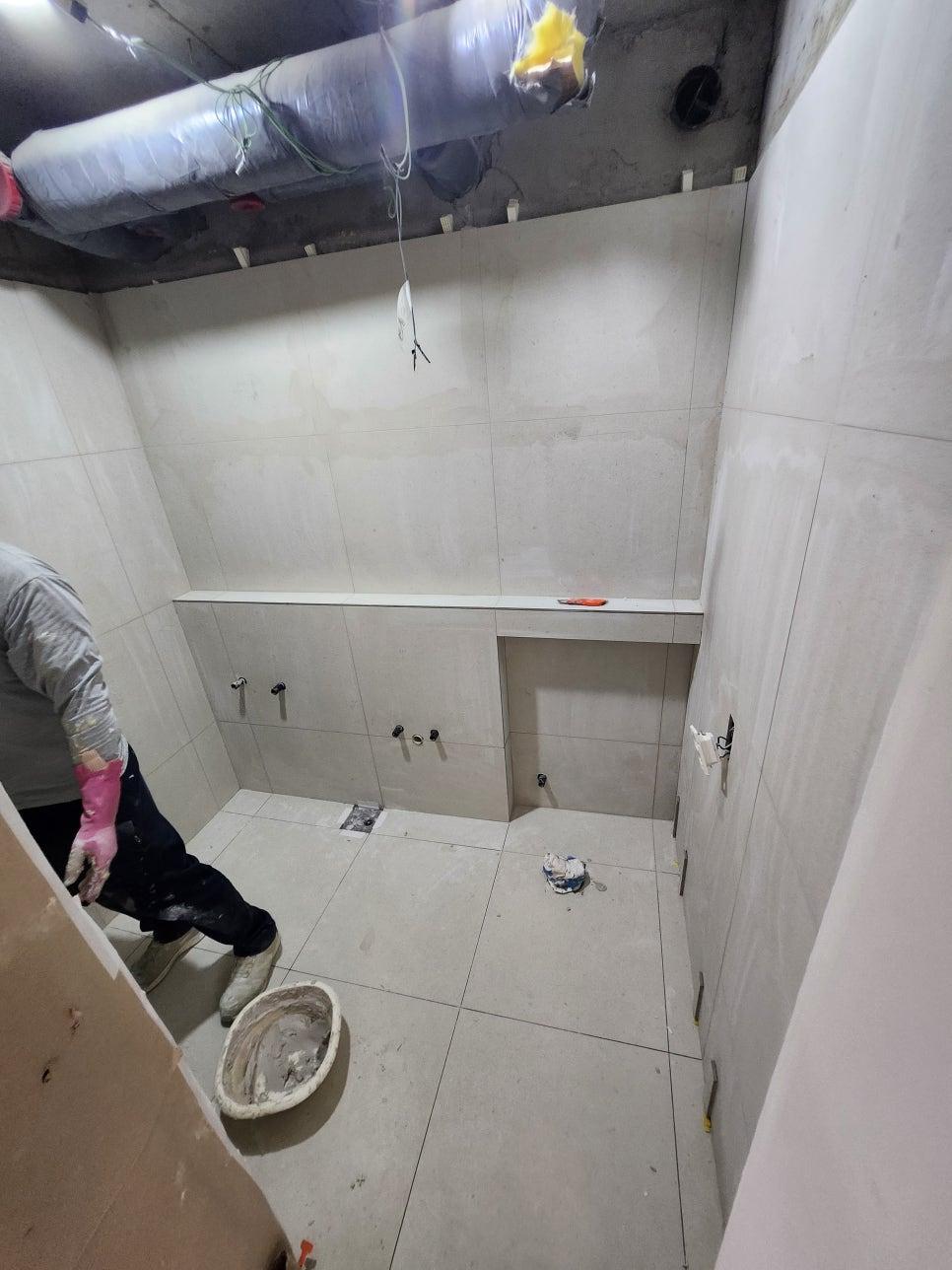 수공구를 이용해 타일 마감을 다듬는 장면