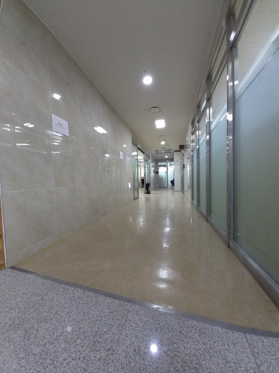 베이지색 타일 벽면과 섬유 마감재가 깔린 바닥
