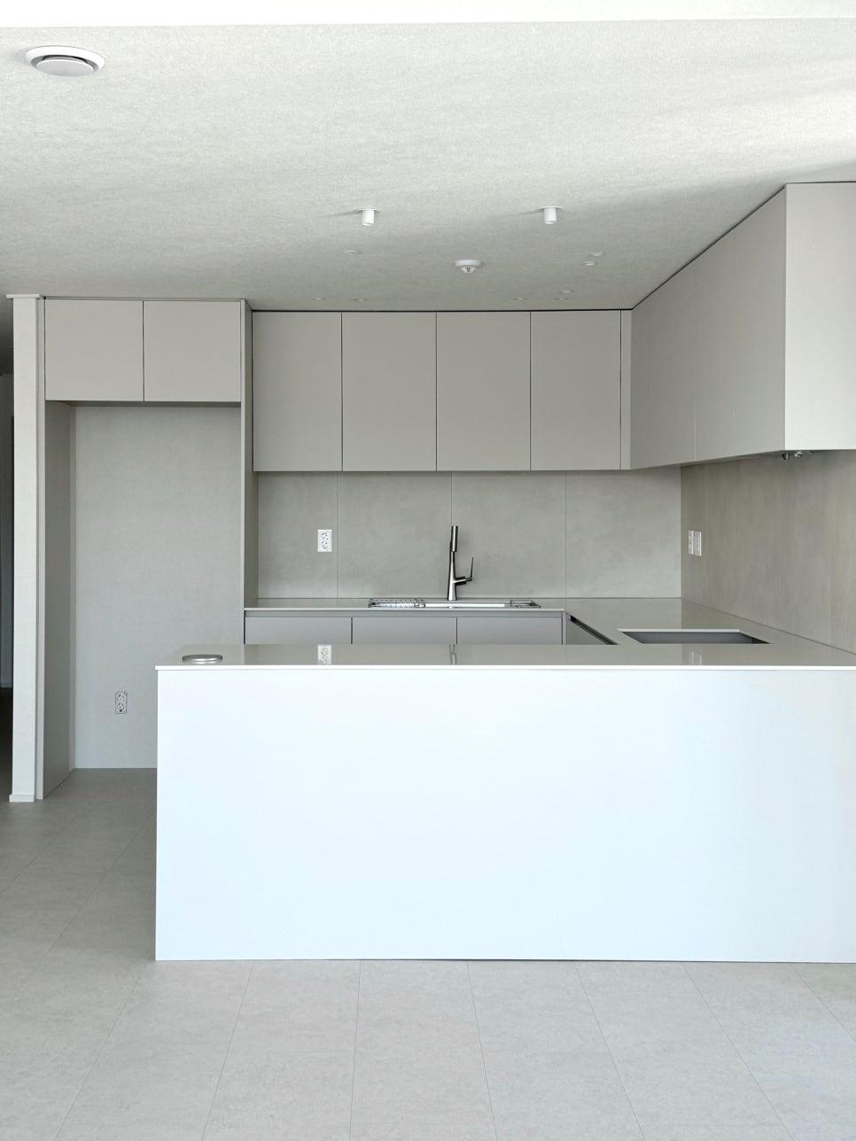 흰색 아일랜드 상판이 놓인 ㄷ자 주방