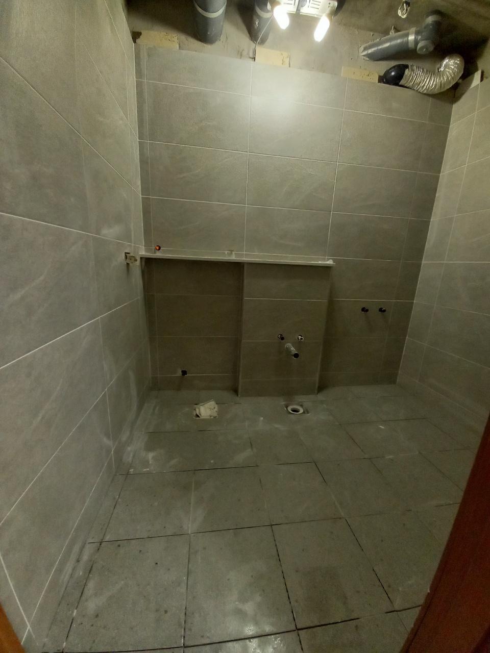 회색 타일로 마감된 벽면과 천장 배관 상태