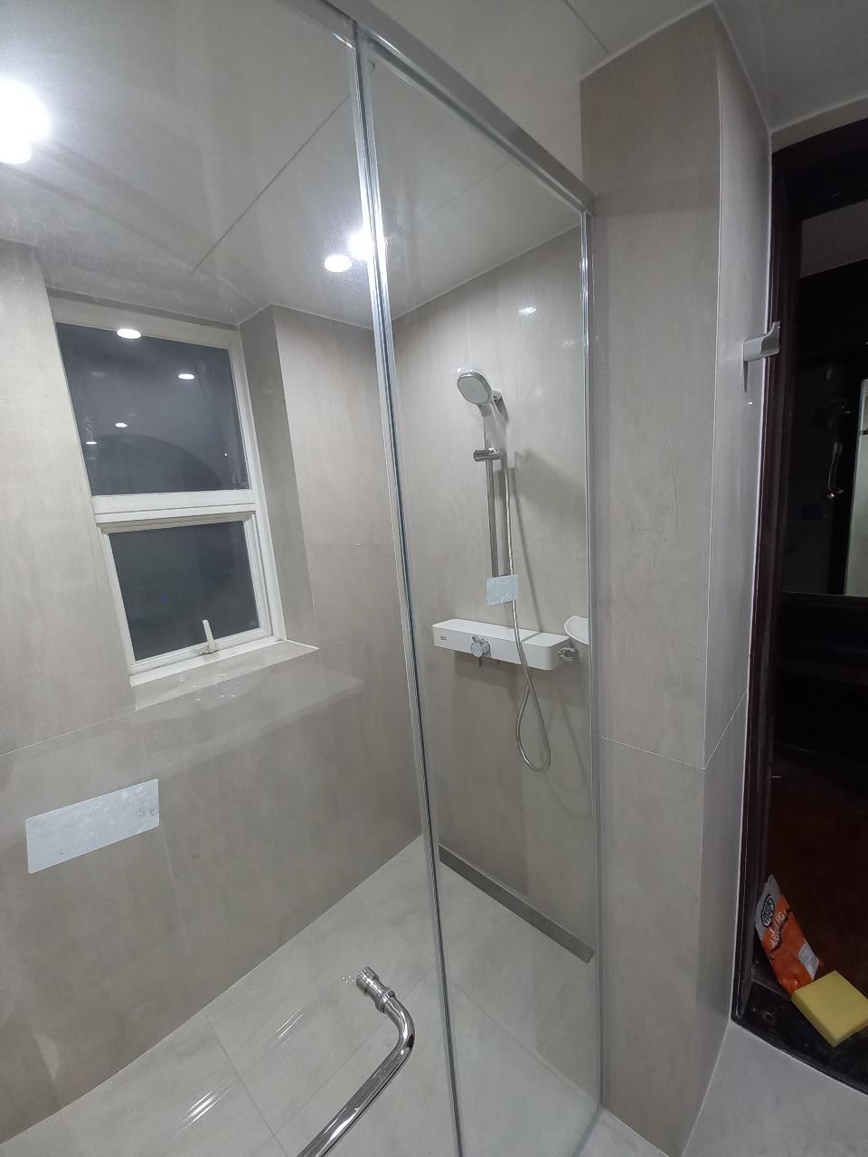 벽 수납장과 샤워 설비가 배치된 타일 벽면