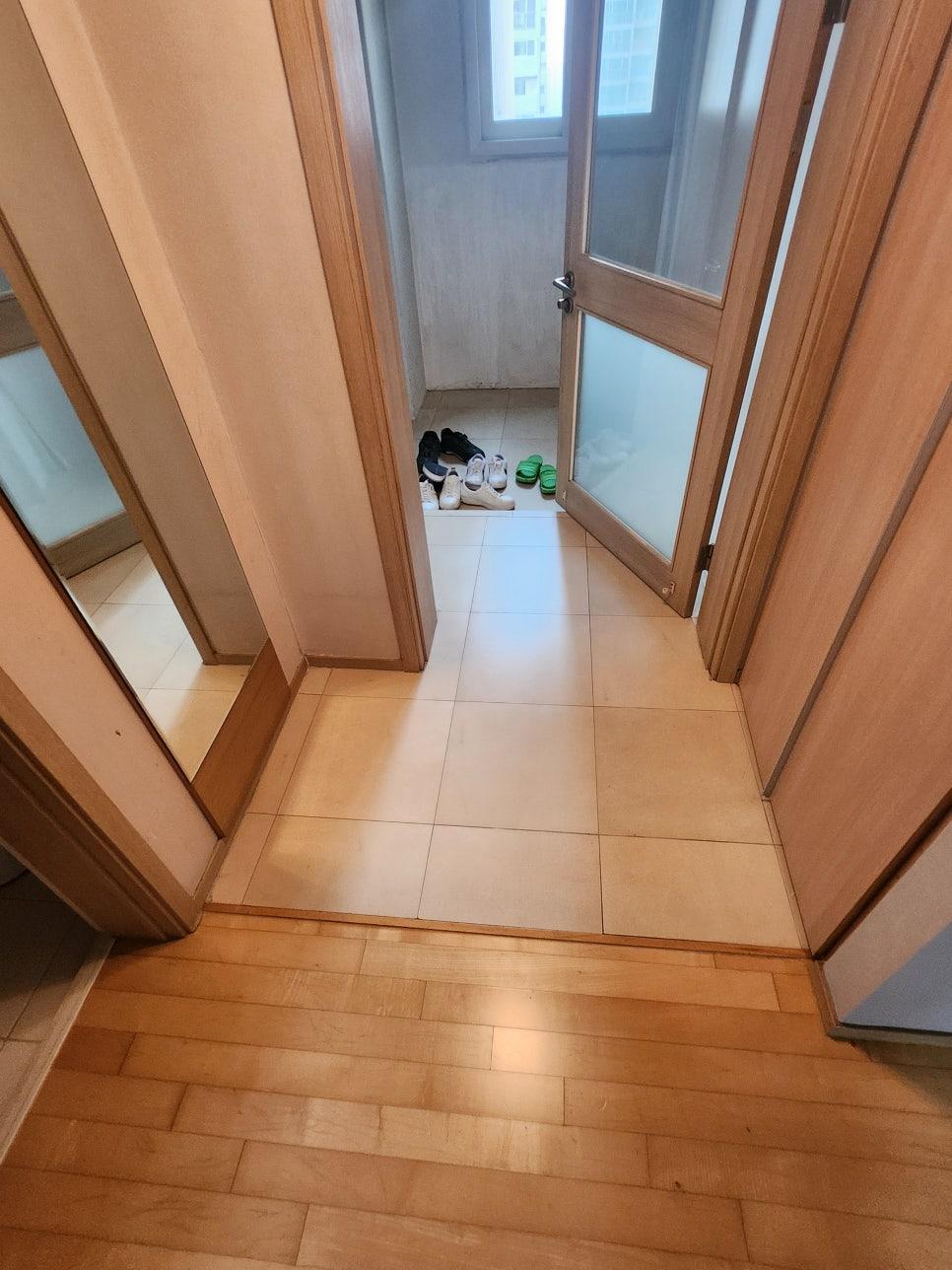 바닥 타일 작업이 진행 중인 현관 통로