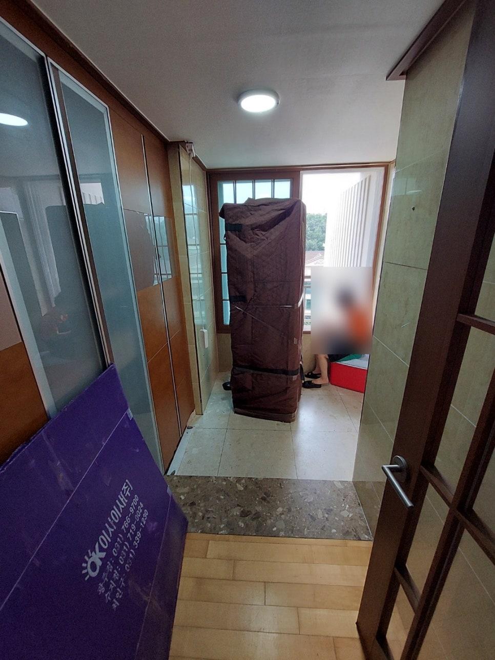 수납장과 나무 문이 보이는 현관 복도 공간