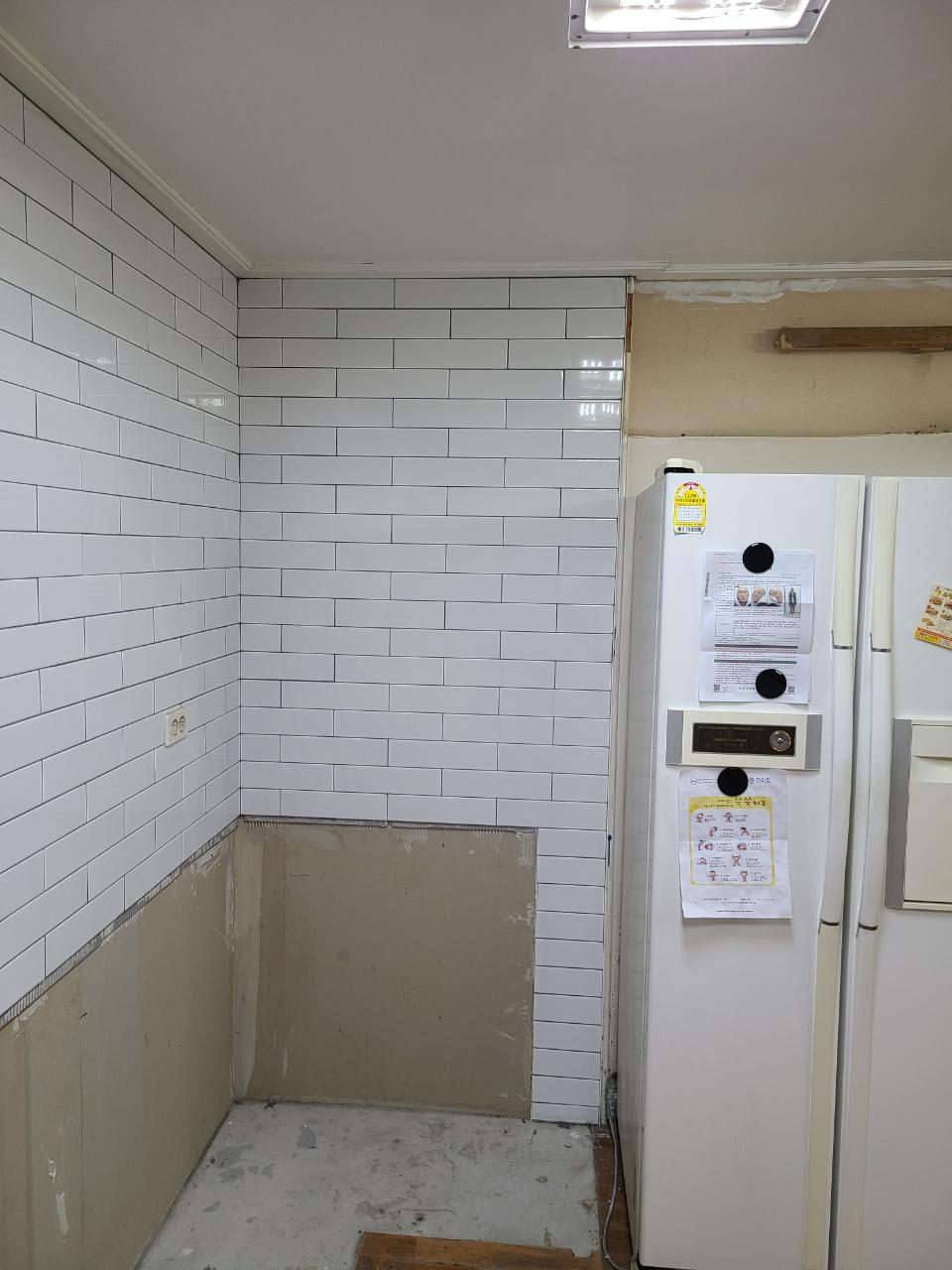 흰색 타일 벽과 벽돌이 노출된 벽면 상태