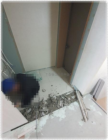 벽면 마감재가 벗겨지고 바닥에 콘크리트 조각이 흩어진 모습