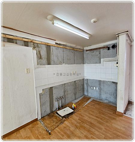 콘크리트 벽면에 화이트 타일을 부착 중인 시공 과정