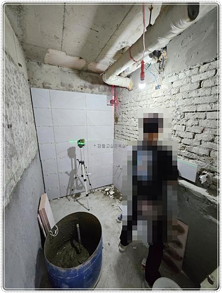 노출 배관과 측정기가 설치된 공사 중인 욕실