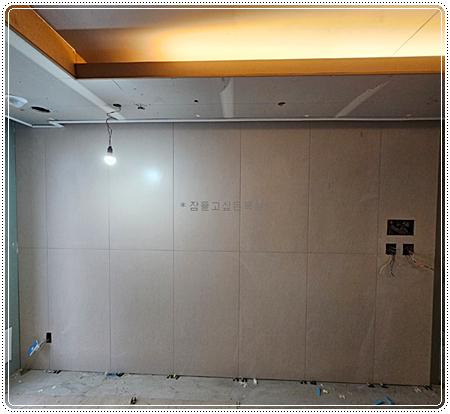 대형 타일을 세로로 부착 중인 아트월 벽면