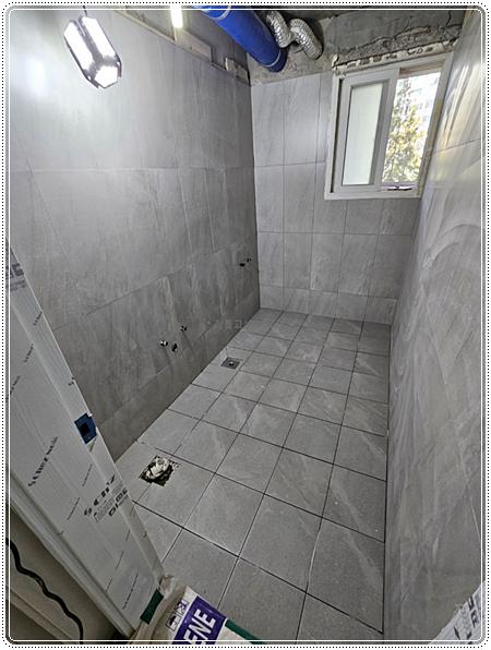 회색 타일 마감과 천장 배관이 보이는 모습