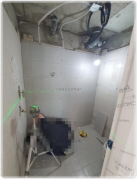 레이저 측정기로 수평을 맞추며 타일을 시공하는 과정